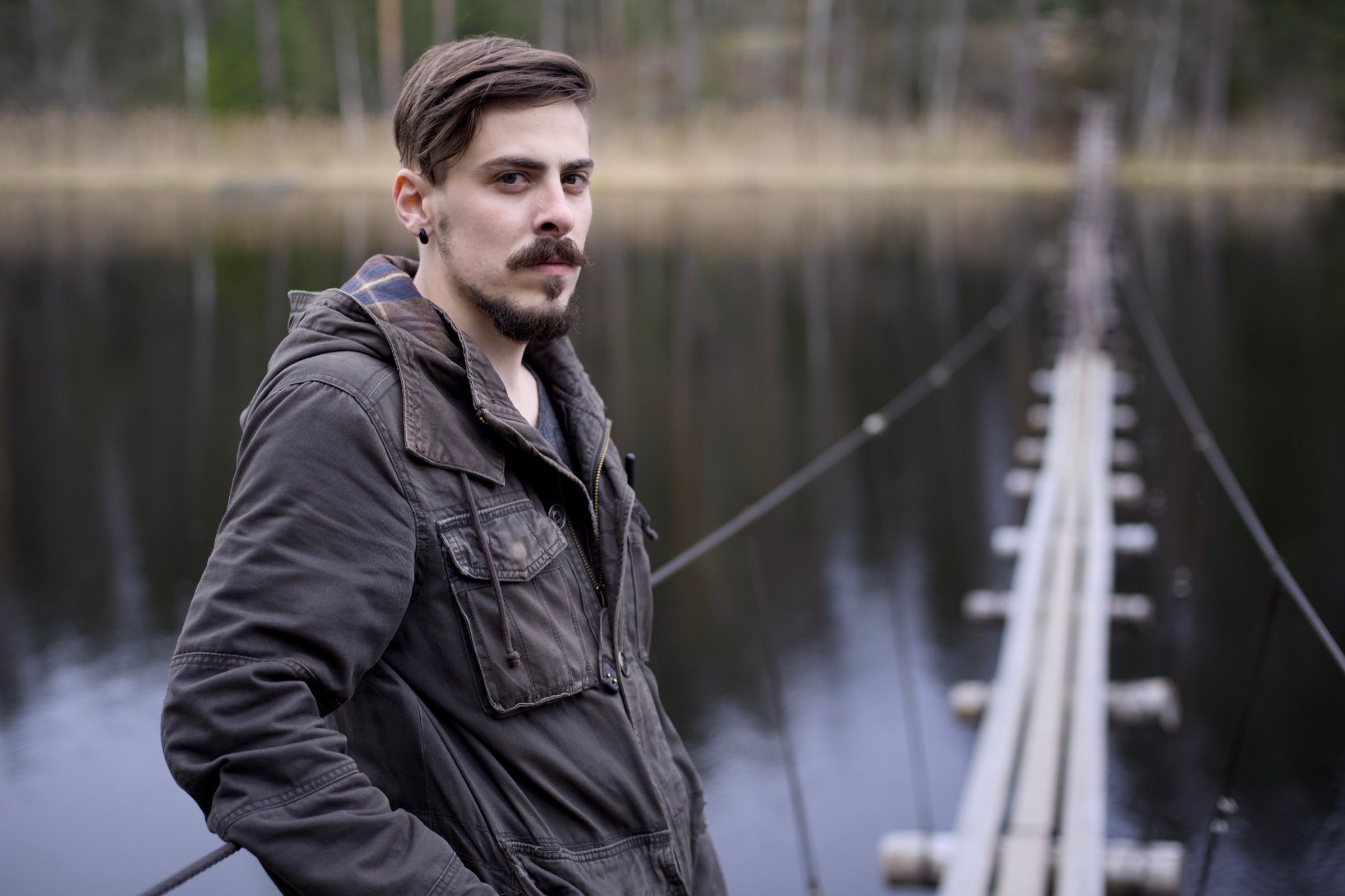 Man by a lake with a wooden jetty
